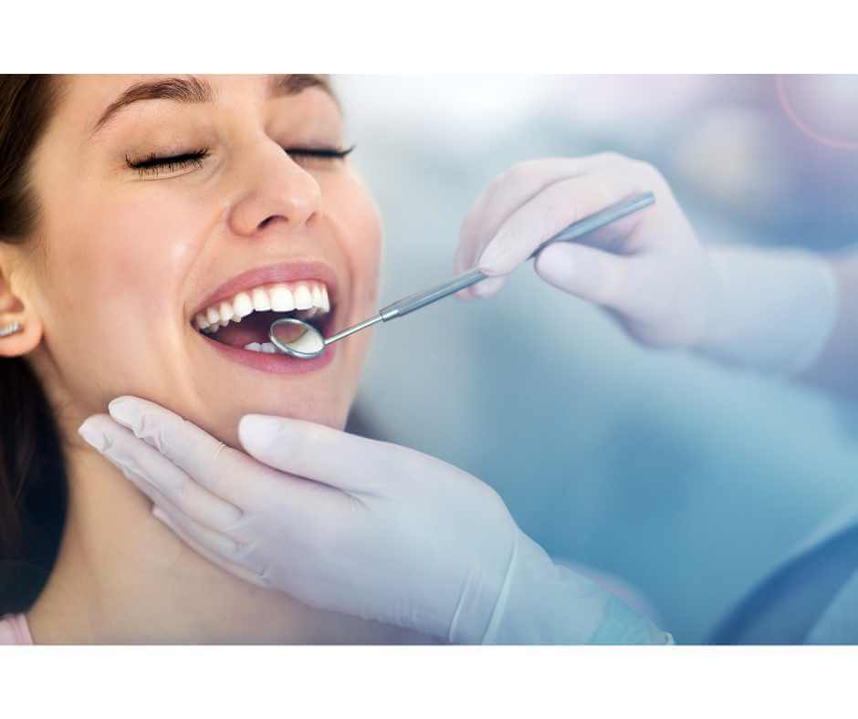Dentist examining patient’s mouth with a dental mirror, highlighting the link between oral health and chronic disease
